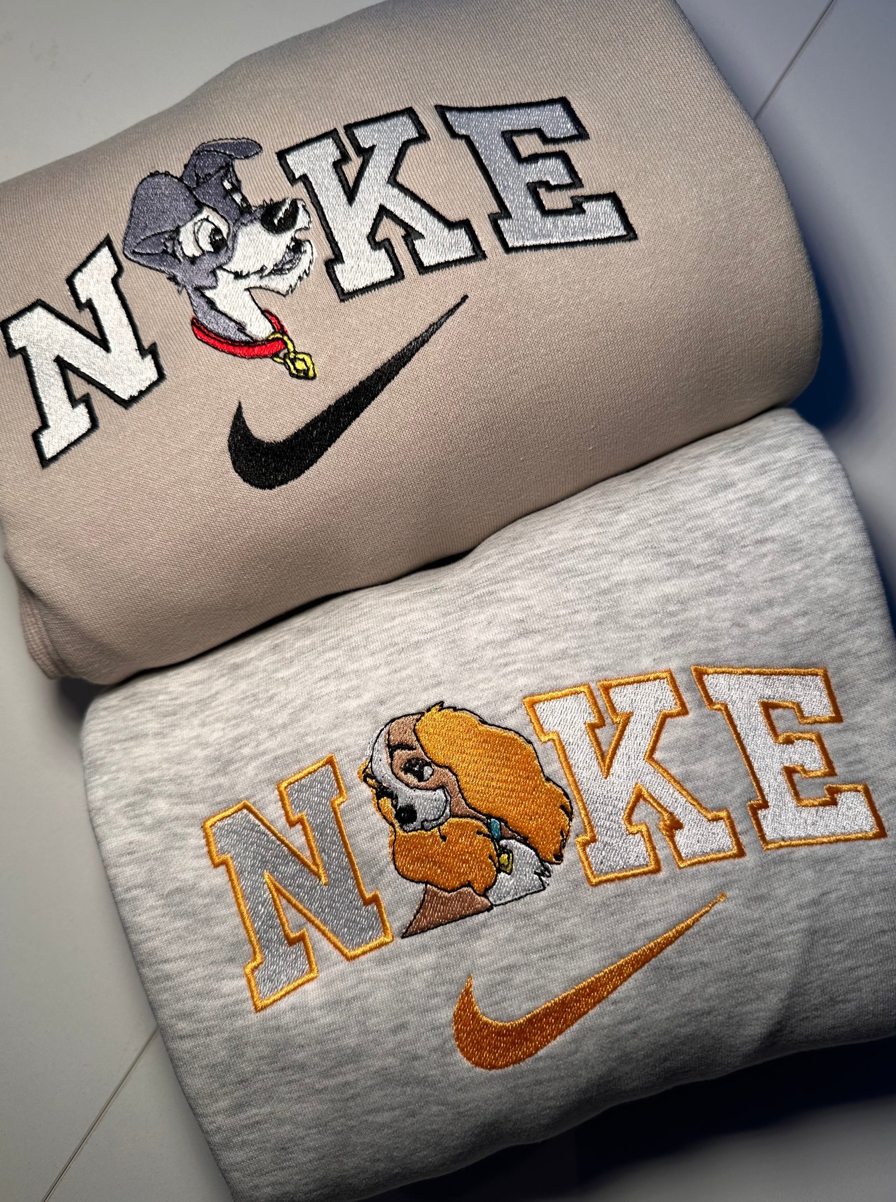 La Belle et le Clochard matching sweatshirts featuring Nike logo and embroidered characters on beige and gray fabric